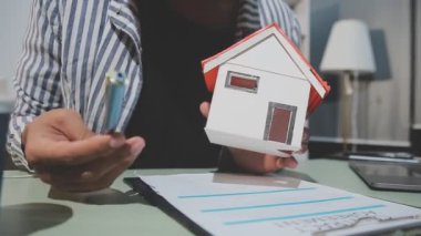 Emlakçı ev almak için kontrat imzalıyor.