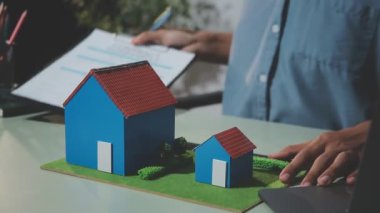 Tablet üzerinde ev modelinde çalışan adam.