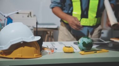 Ofiste miğfer, miğfer, aletler, plan, inşaat malzemeleri, mühendislik, inşaat alanı kavramı ile çalışan inşaat mühendisi