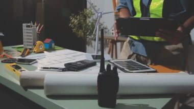 İnşaat alanında proje ve dizüstü bilgisayarla çalışan mühendis veya mimar, mühendislik mühendisliği ve proje.