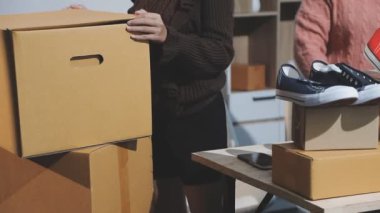 Mağazada bir sürü elbisesi olan genç bir kadın var.