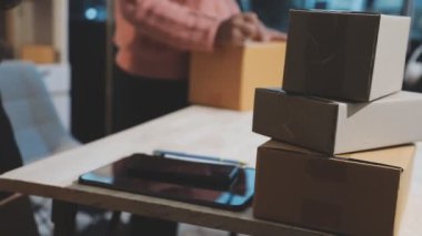 Adam karton kutu paketliyor.