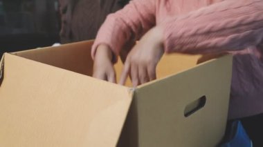 man in a cardboard box with a package for the delivery service, close up