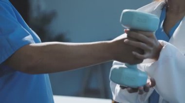 Doktor kadına halteri gösteriyor