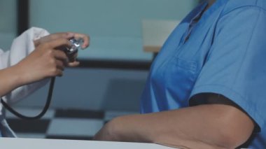 Üniformalı doktor hasta muayene ediyor.