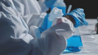 Laboratuvarda elinde şişe tutan bilim adamı, kimyasal deney.