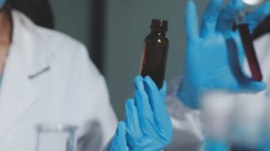 Laboratuvarda bir şişe sıvı ve aşı olan bir doktor.