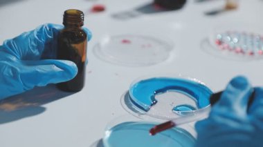 Yakın plan - bir bilim adamının deney tüpünü sıvıyla tutuşu.