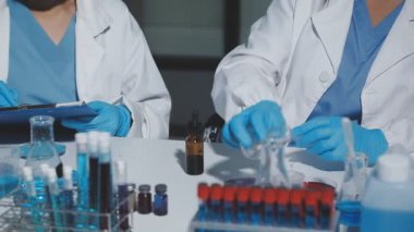 Mikroskopla çalışan iki kadın tıp bilimcisi.