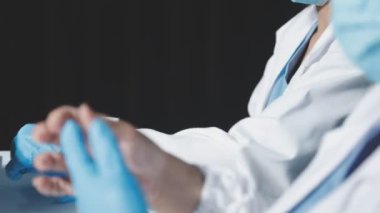 Beyaz önlüklü ve tıbbi eldivenli bir doktor elinde bir test tutuyor..