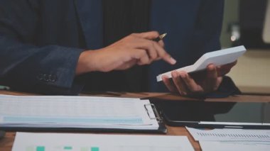 İş adamı, iş yerinde hesap makinesi ve hesap faturaları kullanıyor.