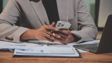 Ofisinde hesap makinesi olan genç bir işadamı.