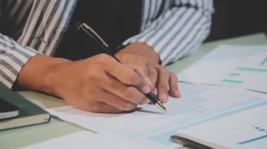 Ofisteki masanın üzerine not defteriyle yazan iş adamı..