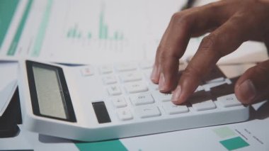 Ofis masasında çalışan iş adamı, hesap makinesi, finansal belgeler kullanıyor..
