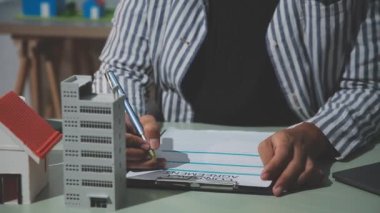 İş adamı, mühendis ya da mühendis ya da mimar takımı ev yapımı ya da inşaat projesine sahip ve ev modeliyle arka planı olan. Yapı konsepti, klasik