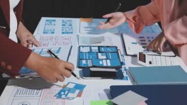 Ofiste bir dizüstü bilgisayar ve mobil uygulama ile iş ekibi toplantısı.