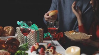 Kırmızı şarap, mumlar ve süslemelerle dolu bir Noel masası. Şenlikli yemek