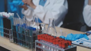Bilim adamı üzerinde bir örnek olan bir test tüpü tutuyor..