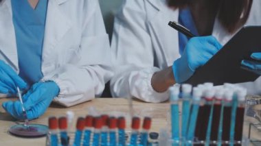 Laboratuvarda elinde kan örneği olan bir bilim adamının tüpünü kapat..