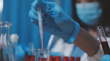 Laboratuvarda elinde tüp tutan bir bilim adamının fotoğrafı.