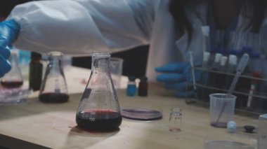 Laboratuvar asistanı laboratuarda kimyasal deneyler için sıvı üretir.