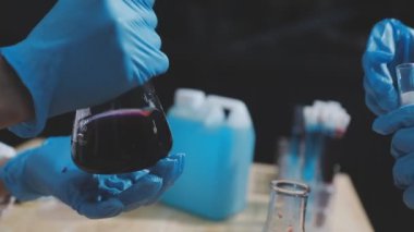 Yakın plan. Laboratuvarda bir bardak kırmızı şarap tutan kadın elleri.