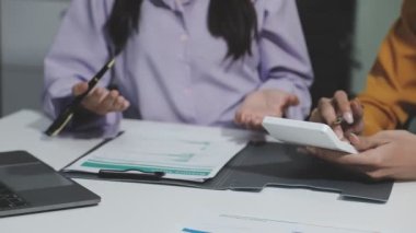 İş adamları modern bir ofiste finansal grafikleri ve grafikleri tartışıyor