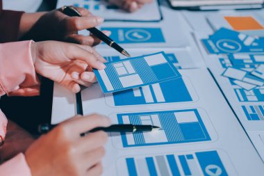 Genç Asyalı iş dünyası yaratıcı takımı mobil uygulama yazılım tasarımı projesinde birlikte çalışıyor. Beyin fırtınası toplantısı, internet teknolojisi, akıllı telefon uygulama tasarımcısı, ofis çalışanı takım çalışması konsepti