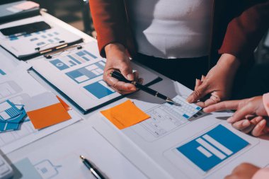 Genç Asyalı iş dünyası yaratıcı takımı mobil uygulama yazılım tasarımı projesinde birlikte çalışıyor. Beyin fırtınası toplantısı, internet teknolojisi, akıllı telefon uygulama tasarımcısı, ofis çalışanı takım çalışması konsepti