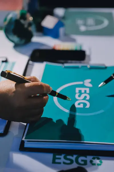 ESG 'nin çevresel sosyal yönetimi, çevre dostu şirket toplantılarında, temiz ve sürdürülebilir gelecekteki ekoloji için çevre korumasını uygulayan iş adamlarıyla dizüstü bilgisayarda sergileniyor. Önde.
