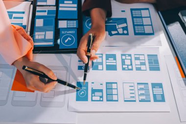 Genç Asyalı iş dünyası yaratıcı takımı mobil uygulama yazılım tasarımı projesinde birlikte çalışıyor. Beyin fırtınası toplantısı, internet teknolojisi, akıllı telefon uygulama tasarımcısı, ofis çalışanı takım çalışması konsepti