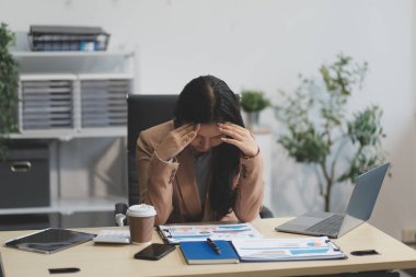 Yorgun ve Asyalı bir kadının portresi ofiste vergi bilgisayarıyla çalışıyor. Üzgün, mutsuz, endişeli, depresyon ya da çalışan hayatı stres konsepti