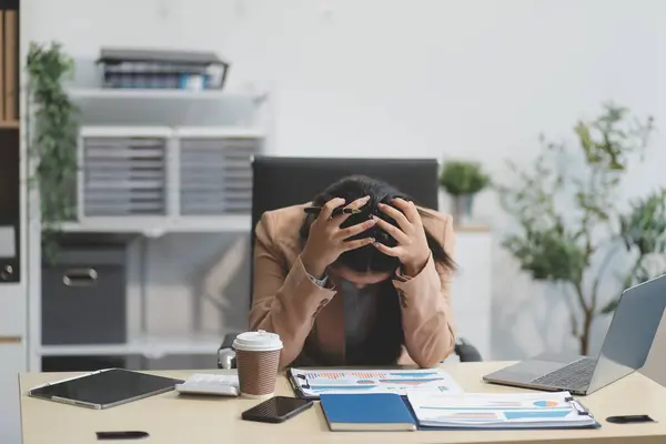 Yorgun ve Asyalı bir kadının portresi ofiste vergi bilgisayarıyla çalışıyor. Üzgün, mutsuz, endişeli, depresyon ya da çalışan hayatı stres konsepti