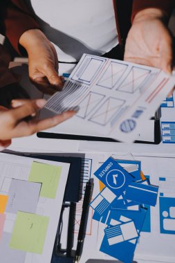 Genç Asyalı iş dünyası yaratıcı takımı mobil uygulama yazılım tasarımı projesinde birlikte çalışıyor. Beyin fırtınası toplantısı, internet teknolojisi, akıllı telefon uygulama tasarımcısı, ofis çalışanı takım çalışması konsepti