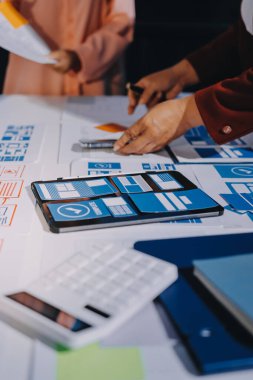 Genç Asyalı iş dünyası yaratıcı takımı mobil uygulama yazılım tasarımı projesinde birlikte çalışıyor. Beyin fırtınası toplantısı, internet teknolojisi, akıllı telefon uygulama tasarımcısı, ofis çalışanı takım çalışması konsepti