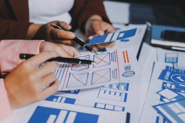 Genç Asyalı iş dünyası yaratıcı takımı mobil uygulama yazılım tasarımı projesinde birlikte çalışıyor. Beyin fırtınası toplantısı, internet teknolojisi, akıllı telefon uygulama tasarımcısı, ofis çalışanı takım çalışması konsepti