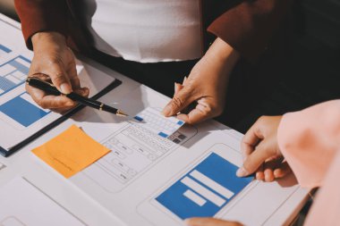 Genç Asyalı iş dünyası yaratıcı takımı mobil uygulama yazılım tasarımı projesinde birlikte çalışıyor. Beyin fırtınası toplantısı, internet teknolojisi, akıllı telefon uygulama tasarımcısı, ofis çalışanı takım çalışması konsepti