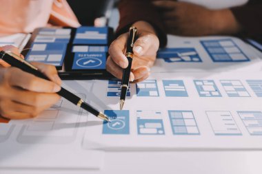 Genç Asyalı iş dünyası yaratıcı takımı mobil uygulama yazılım tasarımı projesinde birlikte çalışıyor. Beyin fırtınası toplantısı, internet teknolojisi, akıllı telefon uygulama tasarımcısı, ofis çalışanı takım çalışması konsepti