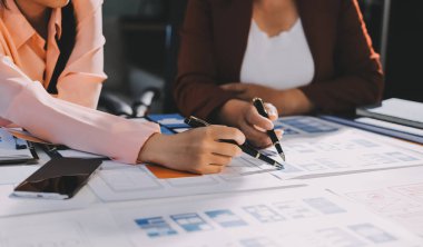 Genç Asyalı iş dünyası yaratıcı takımı mobil uygulama yazılım tasarımı projesinde birlikte çalışıyor. Beyin fırtınası toplantısı, internet teknolojisi, akıllı telefon uygulama tasarımcısı, ofis çalışanı takım çalışması konsepti