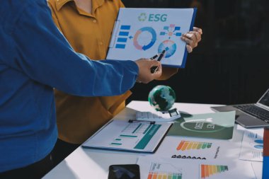 ESG 'nin çevresel sosyal yönetimi, çevre dostu şirket toplantılarında, temiz ve sürdürülebilir gelecekteki ekoloji için çevre korumasını uygulayan iş adamlarıyla dizüstü bilgisayarda sergileniyor. Önde.