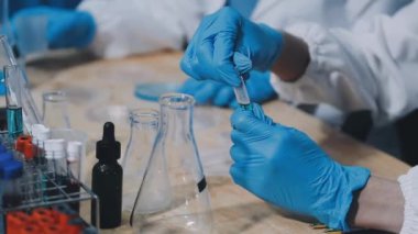 Bir şişe sıvı ile laboratuvar asistanı.