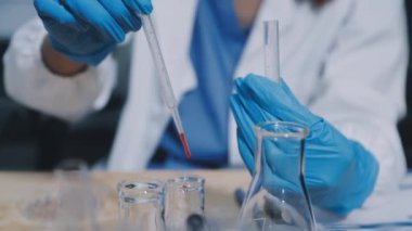 Laboratuvarda çalışan koruyucu eldivenli bilim adamı..