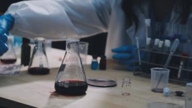 Yakın plan. Laboratuvarda elinde matara tutan bir bilim adamı.