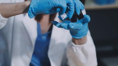 Koruyucu maske ve lateks eldiven takan doktorların ellerini kapatın.