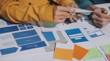 Genç iş tasarımcısı ofiste yeni bir proje üzerinde çalışıyor.