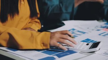 Hesap makinesine yazan genç bir kadın.