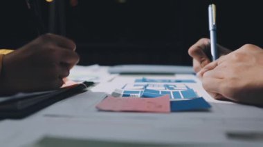 Yakın plan - bir dizüstü bilgisayarda birlikte çalışan ve karanlık bir odada modern bir ofiste notlar yazan iki adam. iş ve finans