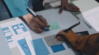 Takımıyla birlikte bir proje üzerinde çalışan genç bir erkek mimarı yakından takip edin..