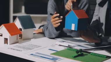 Emlakçı ev modelinin anahtarlarını veriyor, emlak sigortası ve ipotek satın alıyor.