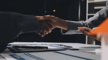 İki işadamı ofiste sözleşme imzaladıktan sonra el sıkışıyor.